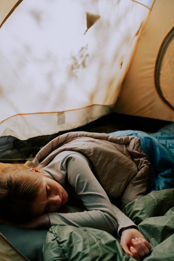 Photo of a Woman Sleeping in a Tent